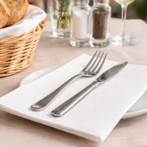 Serwetka gastronomiczna biała 33x33 cm pod sztućcami na stole w restauracji